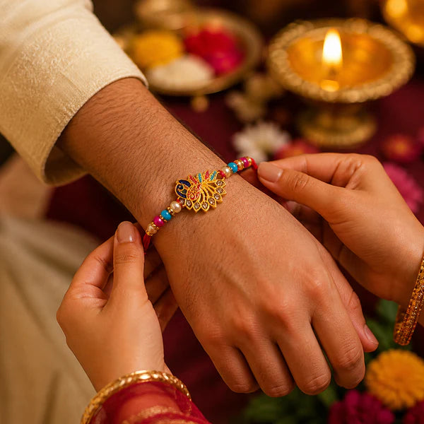 Side view of the Peacock Rakhi showcasing its soft thread and stone details.