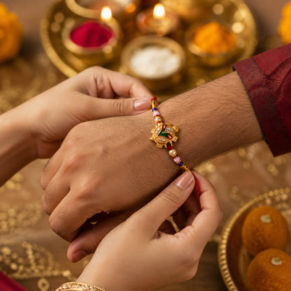 Hand holding Traditional Tortoise Charm Rakhi
