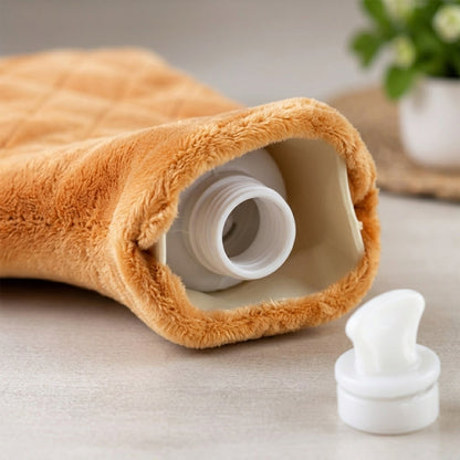 The opening of the orange plush hot water bottle reveals a white screw-top bottle and a detached cap.