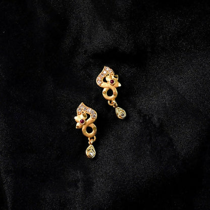 Close-up of ruby and crystal detail on gold earrings
