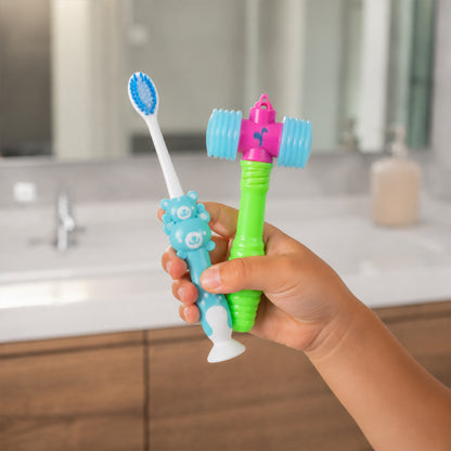 Child's hand holding a blue toothbrush and yellow hammer toy