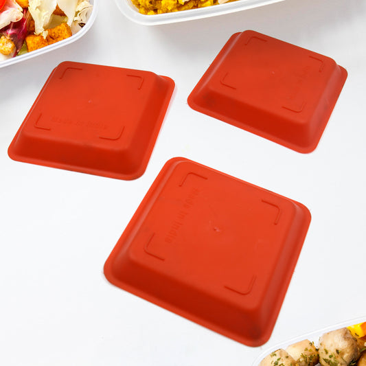 A single square plastic serving tray filled with halwa