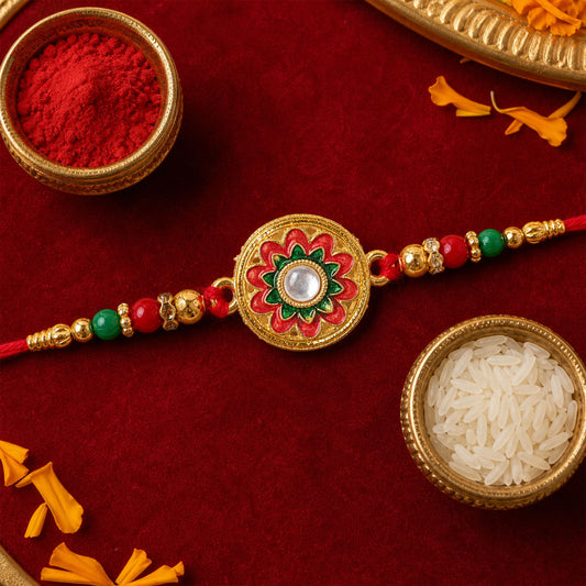 A red thread bracelet with a central gold medallion featuring a red and green enamel flower design, surrounded by red and