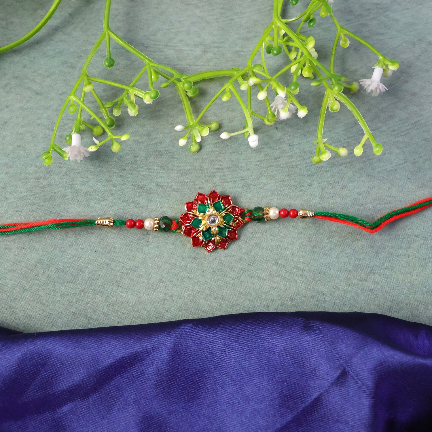 Elaborate Layered Lotus Rakhi Embellished in Red-Green Enamel and a Crystal Core