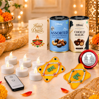 A festive arrangement of Diwali items including two chocolate tins, a greeting card, six LED candles, a remote control, and