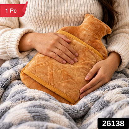 A person holds the orange plush hot water bottle with a quilted cover while sitting on a fuzzy blanket.