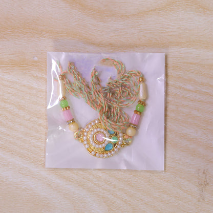 Pearl Bordered Round Pendant Rakhi with Turquoise and Pink Center