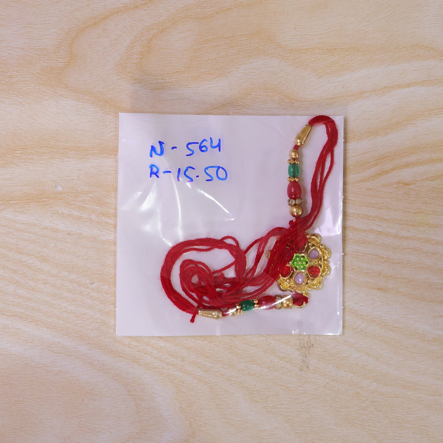 Red and Lilac Kundan Pendant Rakhi with Green Flower Centre
