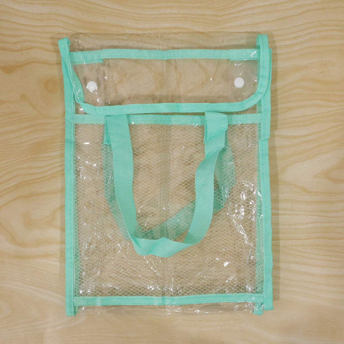 A clear green document bag with a mesh pocket and a snap-button flap, laid flat on a light wooden surface.