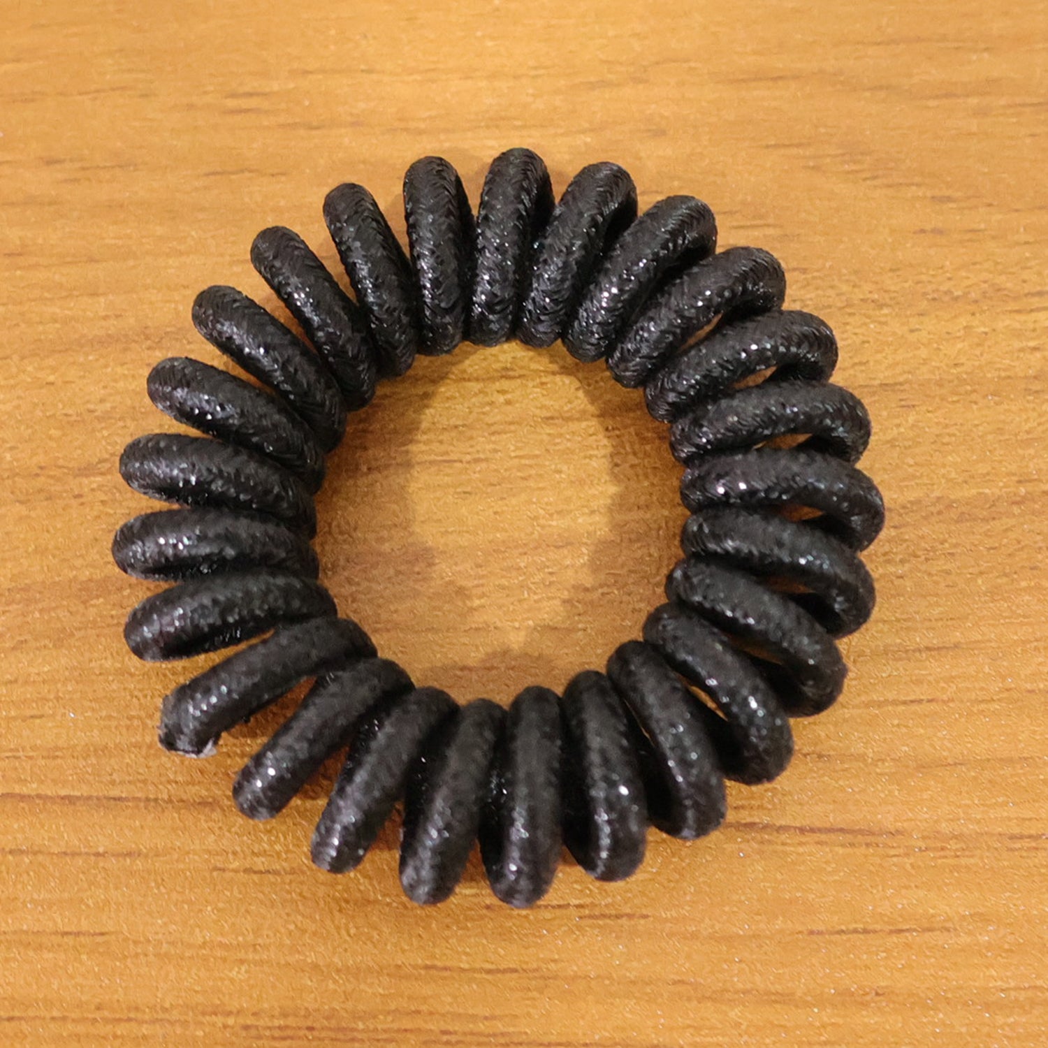 Stretchable coil hair tie in hand