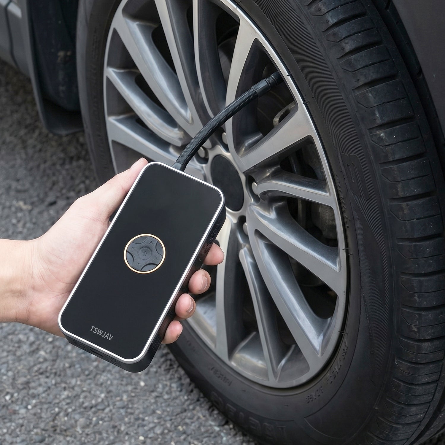 Air pump inflating car tyre on wheel