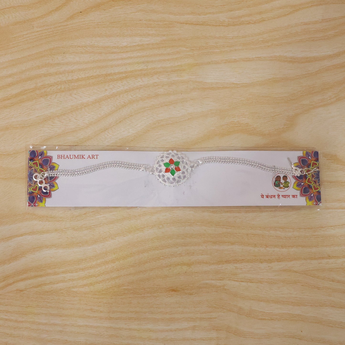 Traditional Rakhi featuring silver floral design and beads
