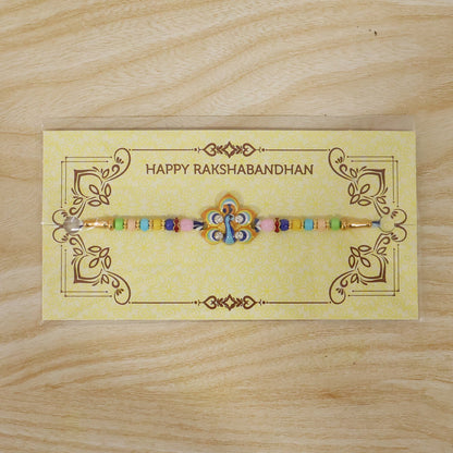 The colorful beaded bracelet with a peacock feather design is presented on a yellow