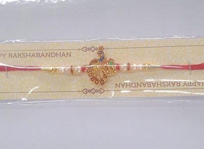 Elegant Peacock Design Rakhi with Pearl Beads and Golden Detailing on Red Thread