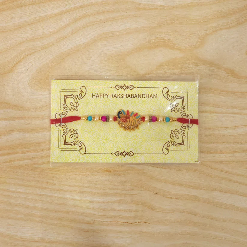 Peacock Rakhi – Colorful Stone Detailing with Red Thread