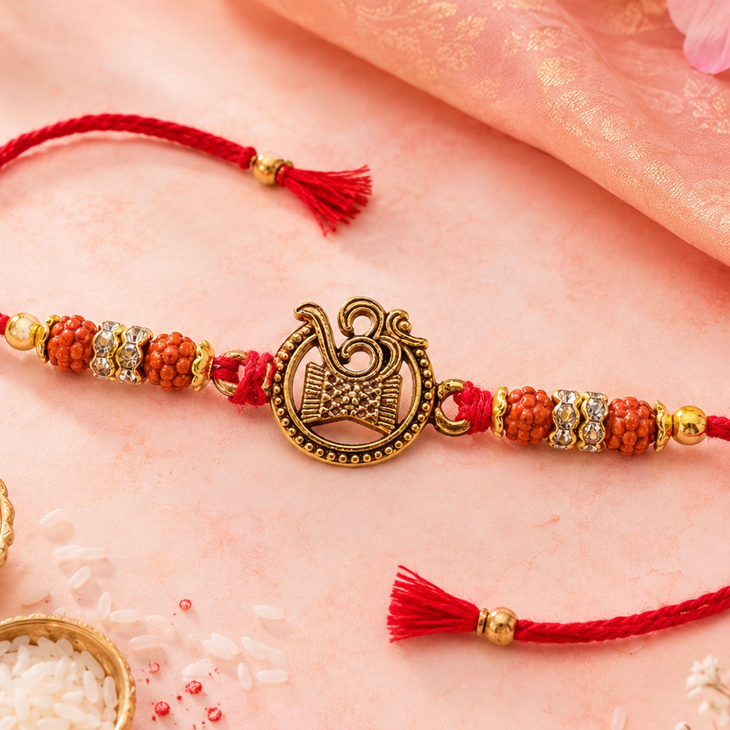 Om Damru Trishul Devotional Rakhi with Golden Centre, Orange Beads and Red Thread