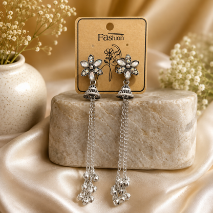 Close-up of oxidised silver jhumka earrings showcasing the ghungroo beads and shimmering stones.