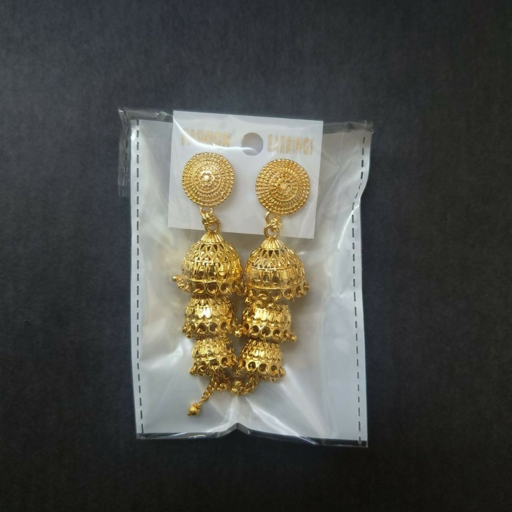 Gold tone jhumki earrings displayed on a white surface