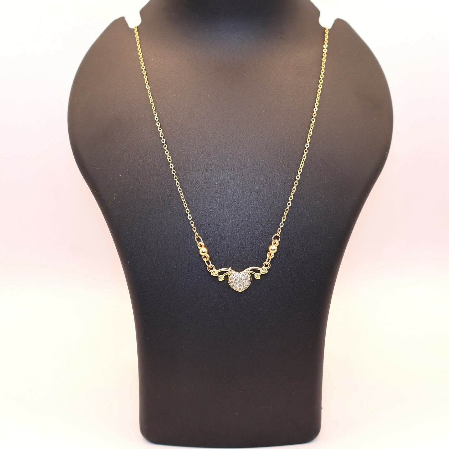 Delicate fine gold chain with gold heart love pendant adorned with CZ stones