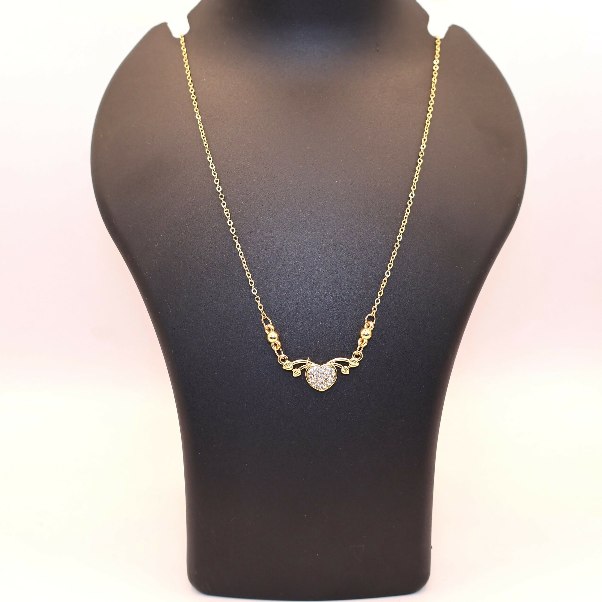 Delicate fine gold chain with gold heart love pendant adorned with CZ stones