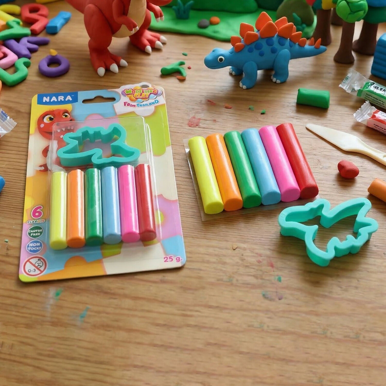 Child using dinosaur-shaped cutter on colourful modelling clay