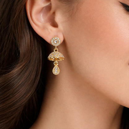 Close-up of gold-tone crystal studded floral dome drop earrings showing detailed design