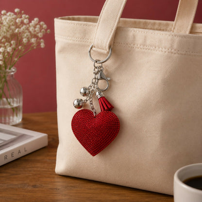 Heart-shaped crystal keychain with tassel on white background