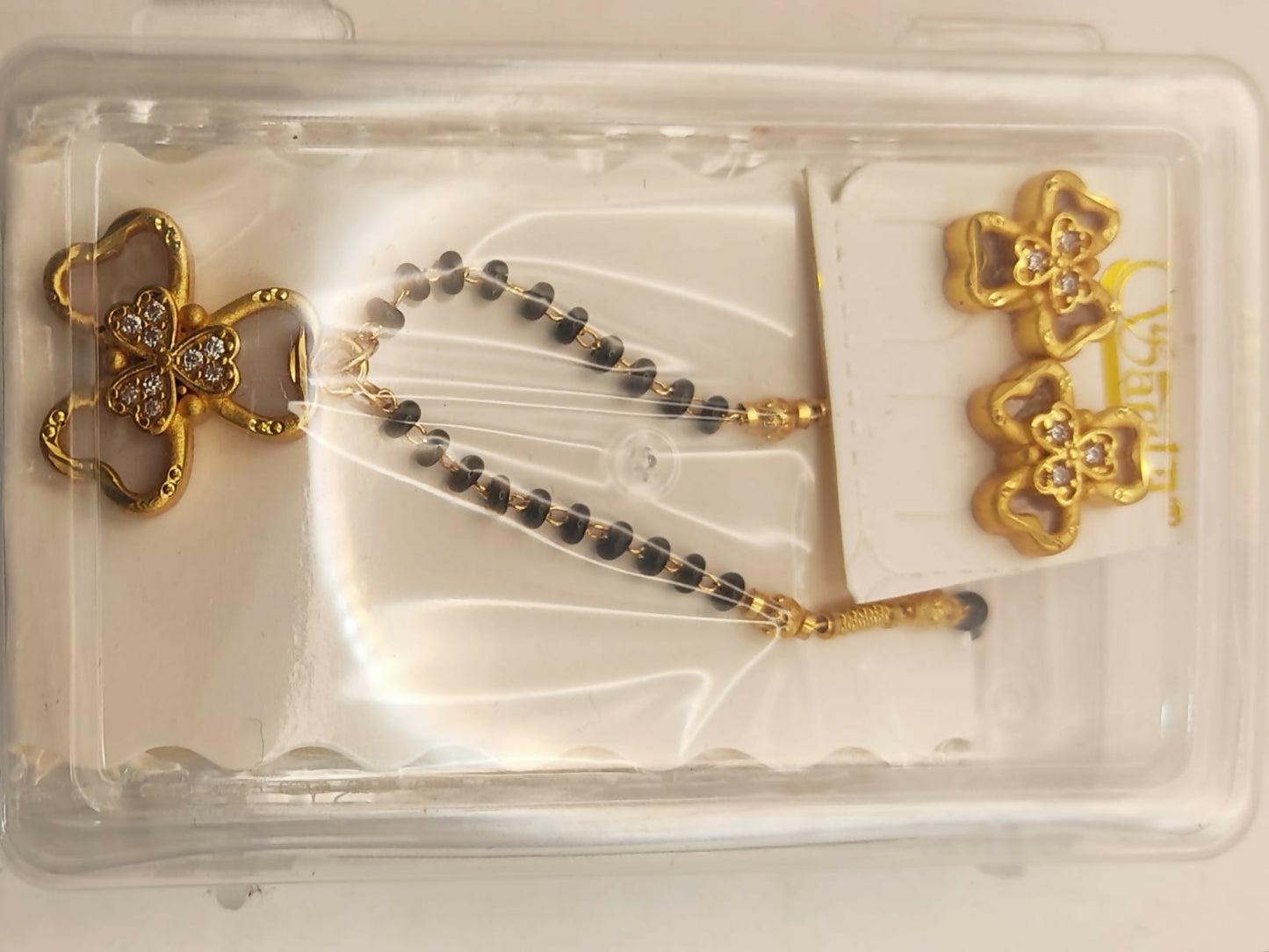 Complete gold-plated AD floral mangalsutra set displayed on rich blue background