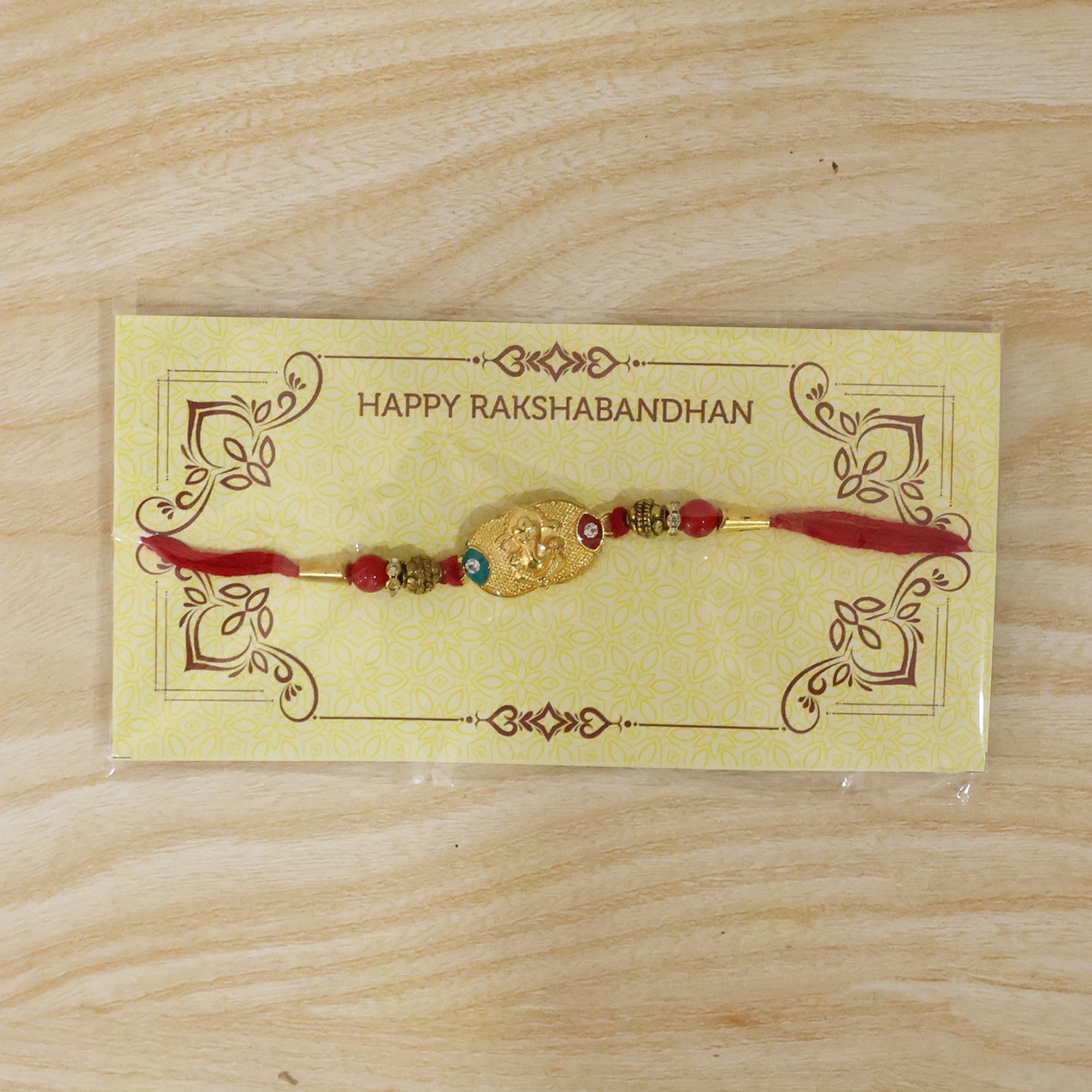 Golden Ganesh Rakhi for Boys with Red and Green Beads