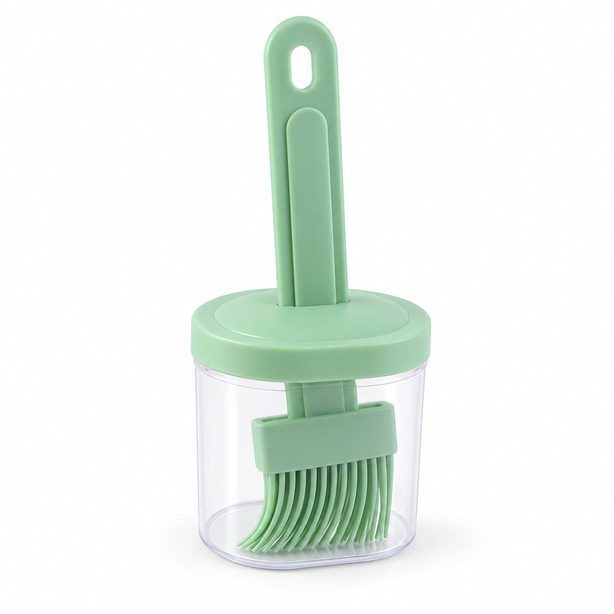The light green silicone basting brush is stored upright within its clear plastic container, topped with a matching green