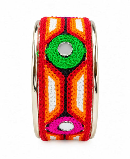 A studio shot of the embroidered cuff bracelet, showcasing its intricate design and reflective mirrors against a white