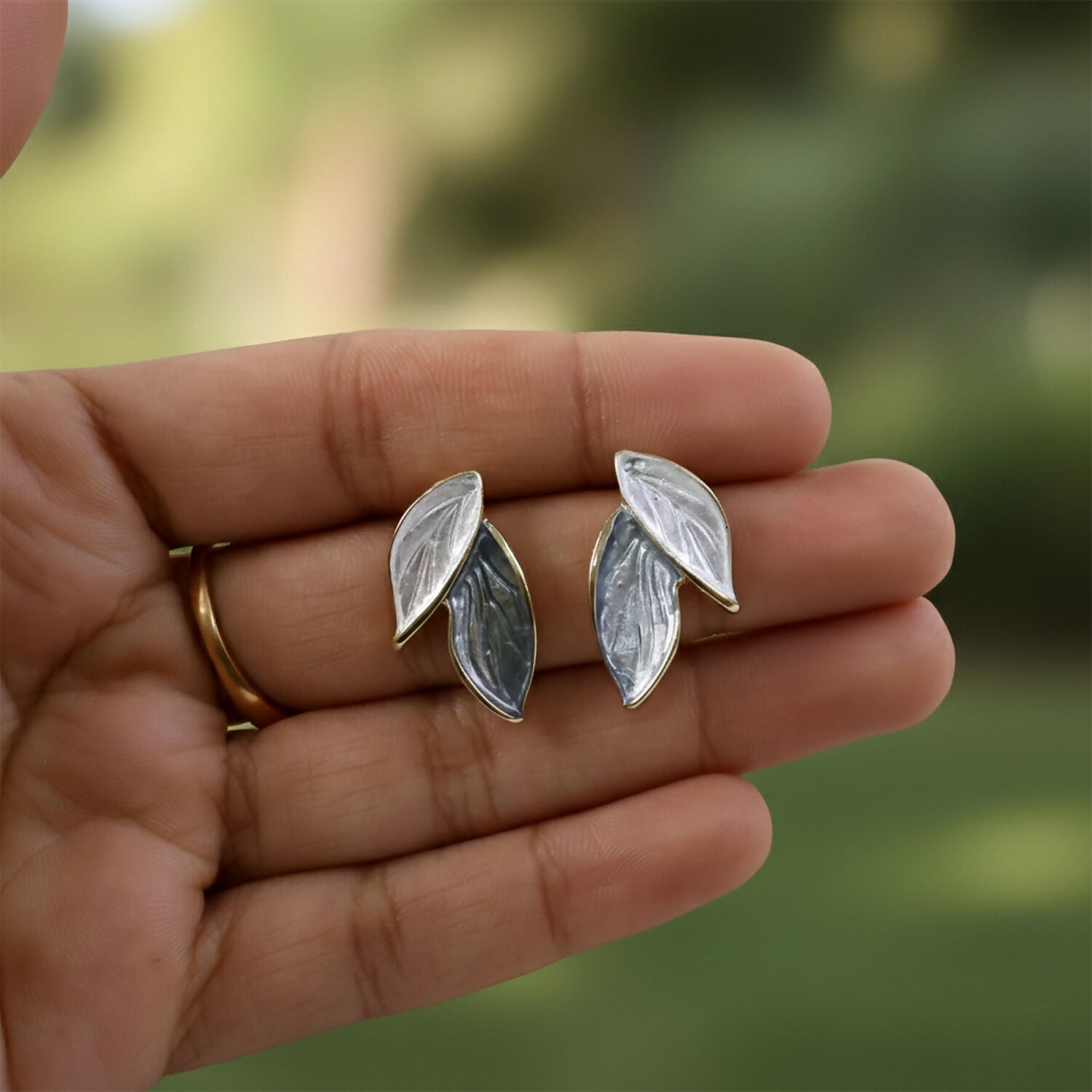 Close-up of grey and white leaf design earrings
