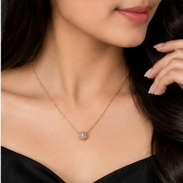 Gold-tone necklace with delicate chain and rounded floral pendant