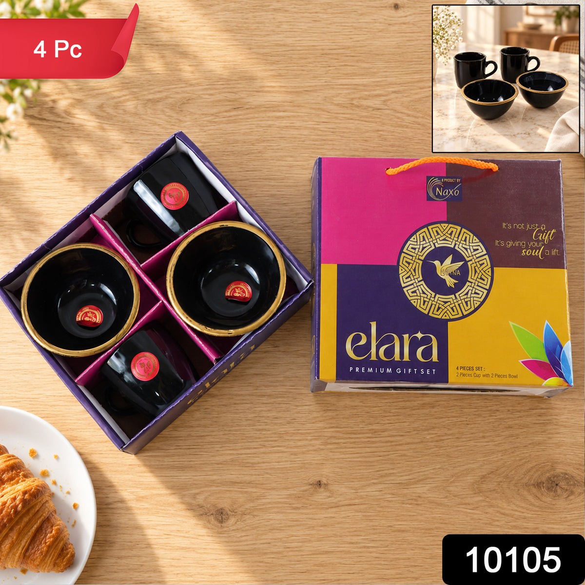 Overhead view of a four-piece black ceramic set with gold rims, two mugs and two bowls, in a purple gift box with a colorful
