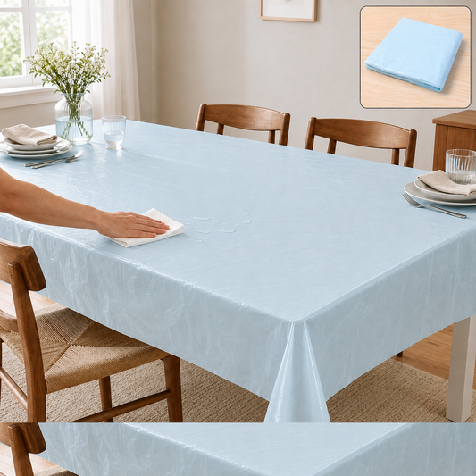 A hand wipes a spill from a light blue plastic table cover on a dining table set for a meal.
