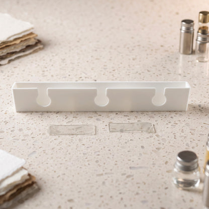 Wine glass hanger with adhesive mounting strips