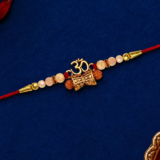 Elegant Golden Charm Rakhi with pearl beads and red thread, perfect for Raksha Bandhan.