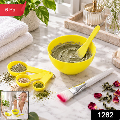 A yellow mixing bowl with a green face mask, a spatula, measuring spoons, and a brush on a marble counter, with an inset of