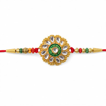 Detailed view of the Kundan work and the vibrant green and red stones on the Rakhi.