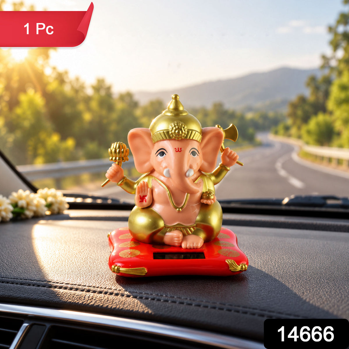 A peach and gold Ganesha idol on a red cushion with a solar panel, on a car dashboard with a sunset view.
