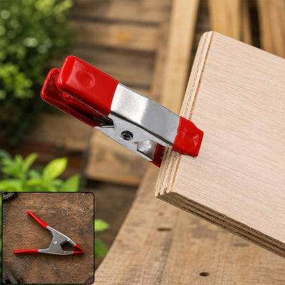 Metal spring clamp holding wooden board
