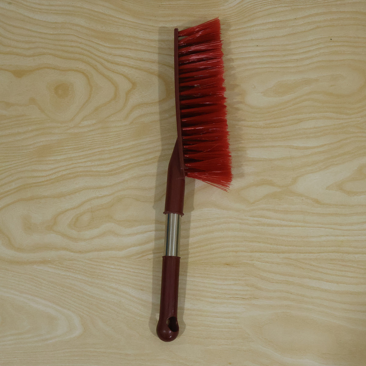 Red long handle cleaning brush in a home cleaning setting