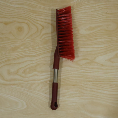 Red long handle cleaning brush in a home cleaning setting
