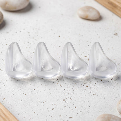 Four transparent table corner protectors