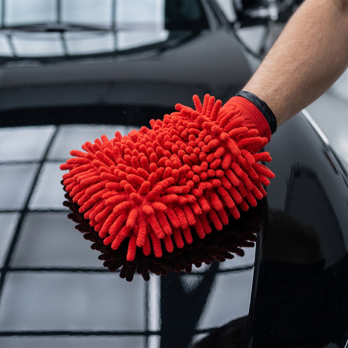 Microfiber chenille cleaning glove shown on hand for car washing