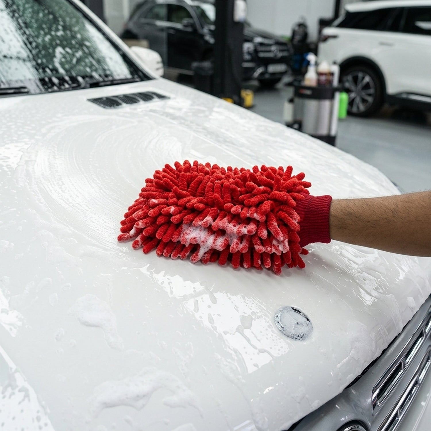 Red microfiber wash glove cleaning a car surface