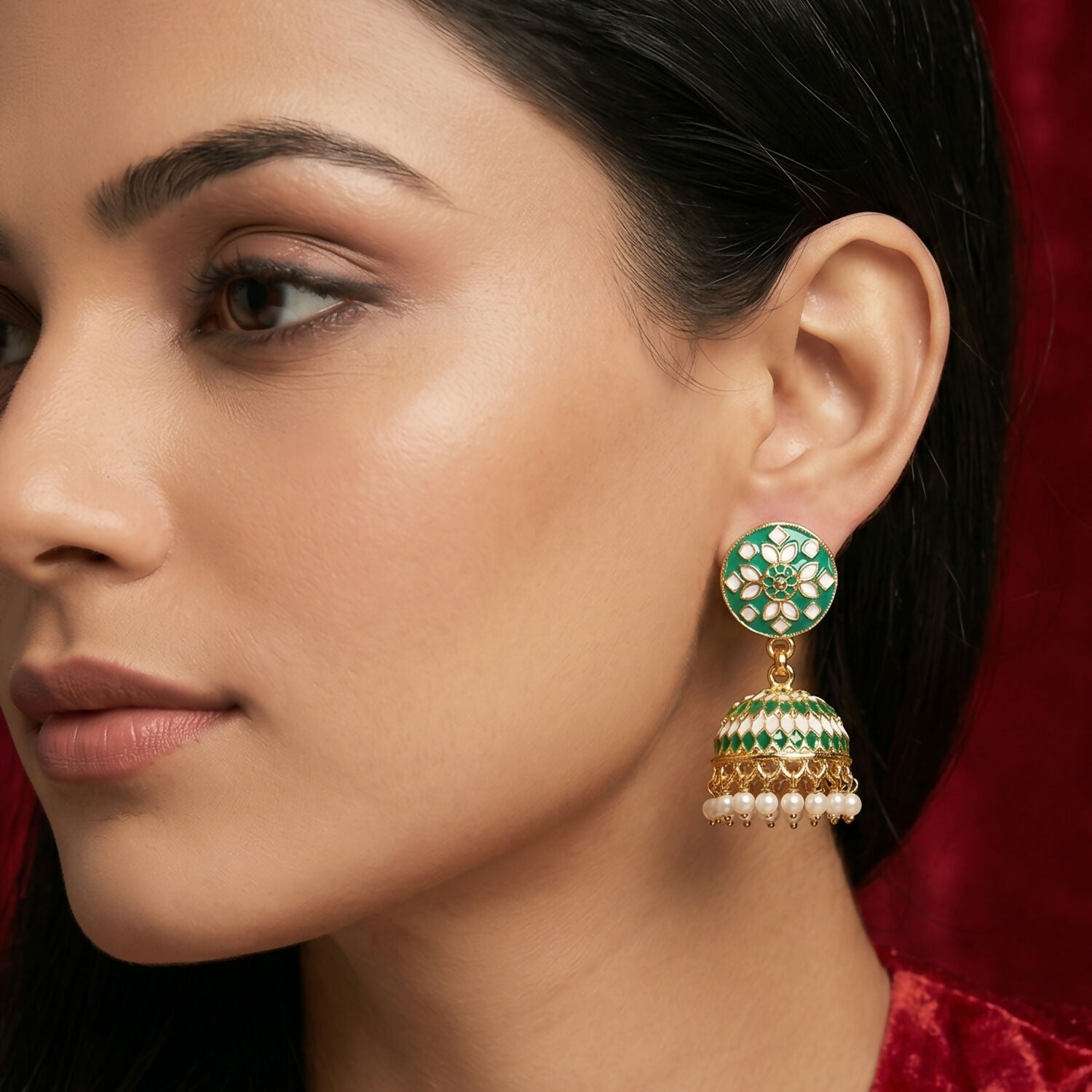 Side view of green floral jhumka earrings with pearls