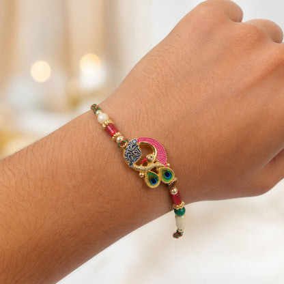 Peacock Rakhi Set with Red Thread, Gold Beads and Meenakari Accent Design