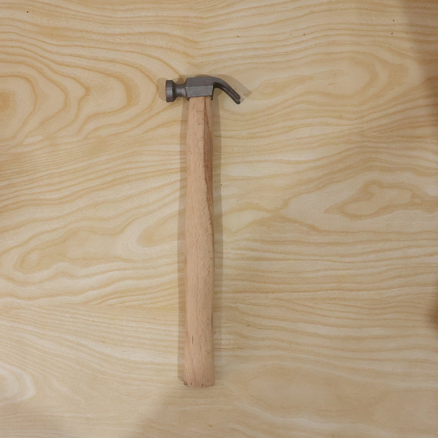 Hammer shown from side on wooden surface