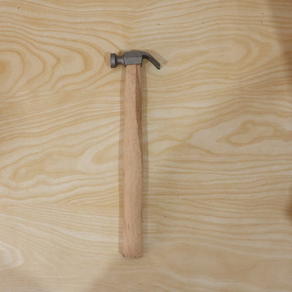 Hammer shown from side on wooden surface